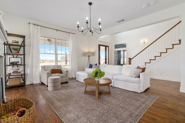 living room featuring a notable chandelier, dark wood-type flooring, visible vents, and a healthy amount of sunlight