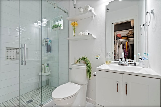 full bath with a stall shower, a walk in closet, toilet, and vanity