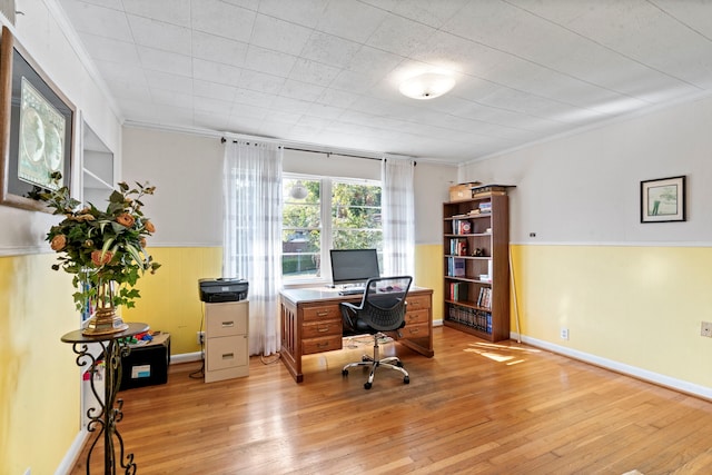 home office featuring a wainscoted wall, ornamental molding, and light wood-type flooring