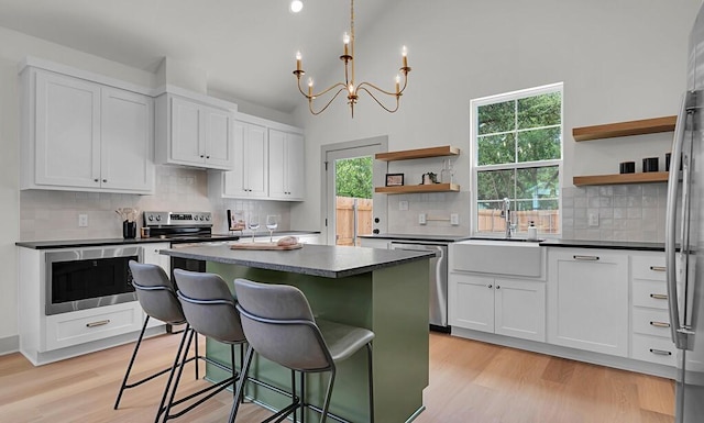 538 Proctor Ave, Waco, TX 76708 - kitchen featuring stainless steel appliances, open shelves, a sink, dark countertops, and high vaulted ceiling