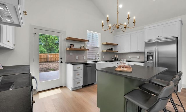 538 Proctor Ave, Waco, TX 76708 - kitchen featuring stainless steel appliances, dark countertops, open shelves, a chandelier, and decorative backsplash