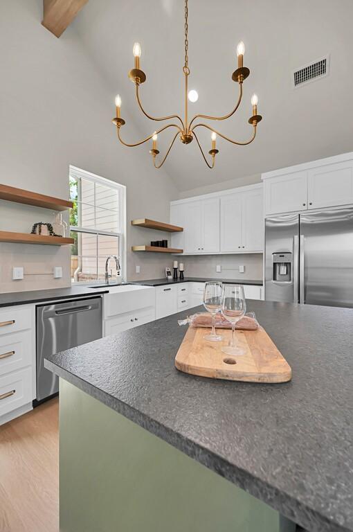 538 Proctor Ave, Waco, TX 76708 - kitchen with appliances with stainless steel finishes, open shelves, dark countertops, white cabinets, and high vaulted ceiling