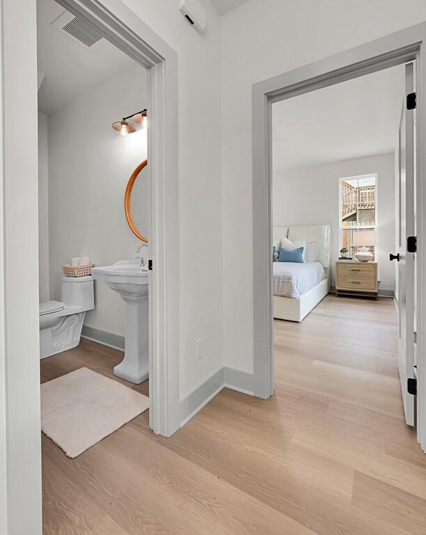 538 Proctor Ave, Waco, TX 76708 - bathroom with wood finished floors, toilet, baseboards, and a sink