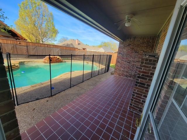 view of patio featuring ceiling fan, a fenced backyard, and a fenced in pool