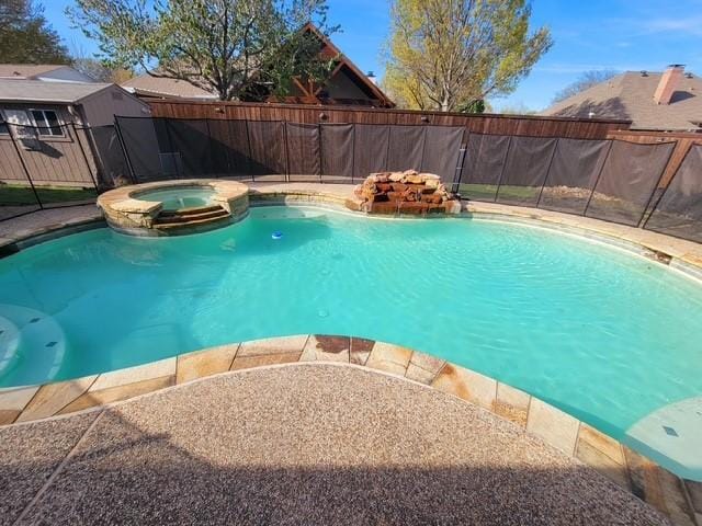 view of swimming pool with a pool with connected hot tub and fence