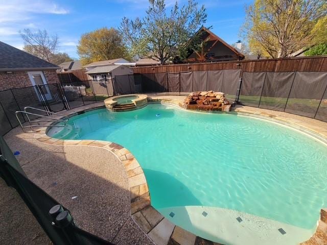 view of swimming pool featuring a storage shed, a pool with connected hot tub, a fenced backyard, an outdoor structure, and a patio area