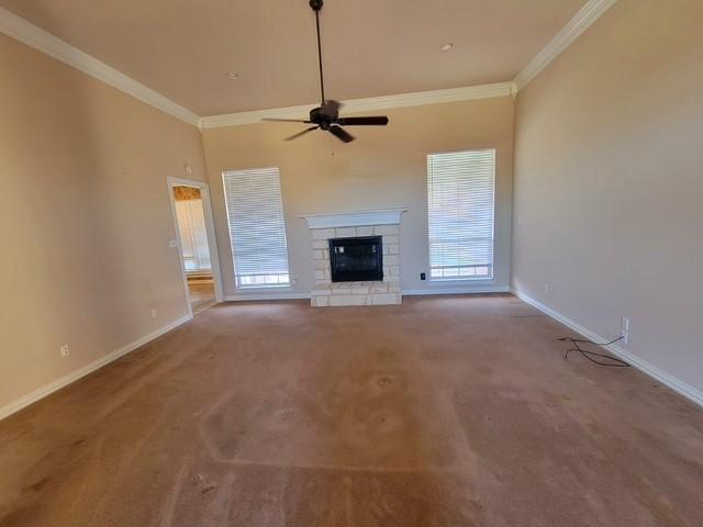 unfurnished living room with a ceiling fan, crown molding, and baseboards