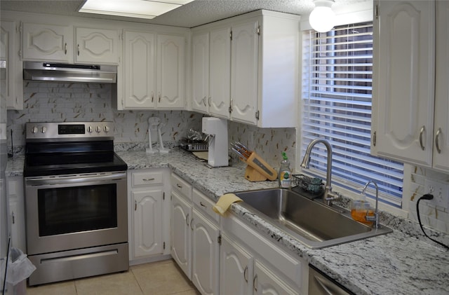 1034 Holland Dr, Garland, TX 75040 - kitchen with white cabinets, stainless steel electric stove, under cabinet range hood, a sink, and light tile patterned floors