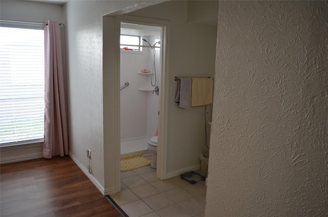 1034 Holland Dr, Garland, TX 75040 - full bath featuring a wealth of natural light, toilet, baseboards, and a textured wall