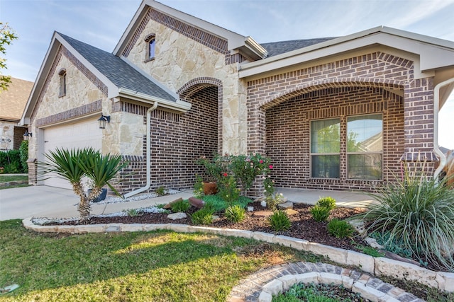 5928 Dunnlevy Dr, Fort Worth, TX 76179 - view of front facade featuring brick siding, an attached garage, stone siding, and concrete driveway