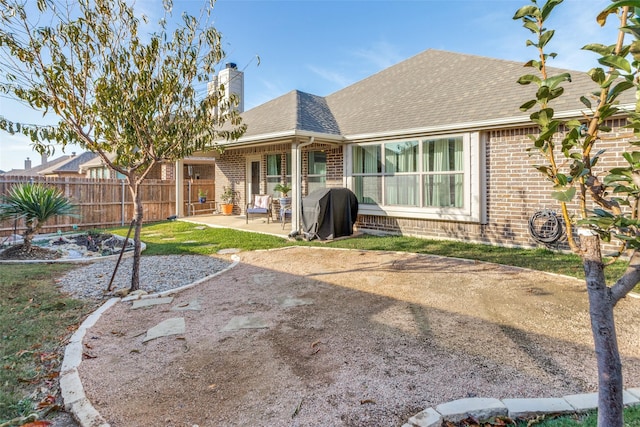 5928 Dunnlevy Dr, Fort Worth, TX 76179 - rear view of house with a shingled roof, a chimney, fence, a patio, and brick siding