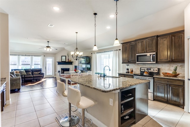 5928 Dunnlevy Dr, Fort Worth, TX 76179 - kitchen featuring ceiling fan with notable chandelier, visible vents, appliances with stainless steel finishes, open floor plan, and a breakfast bar area