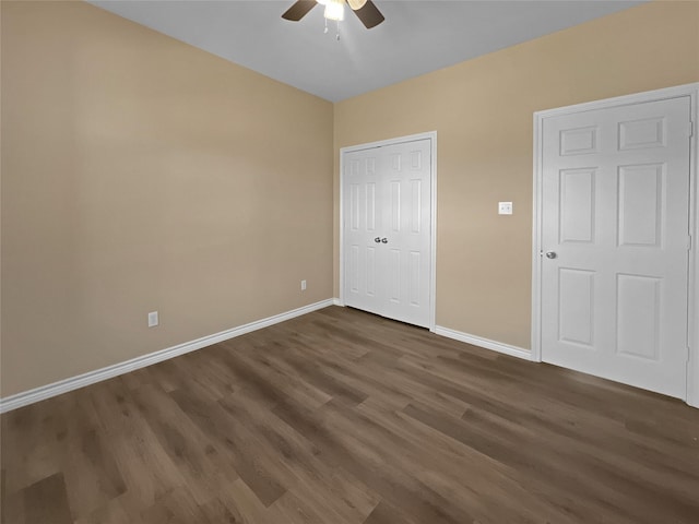 unfurnished bedroom featuring a ceiling fan, a closet, baseboards, and dark wood finished floors