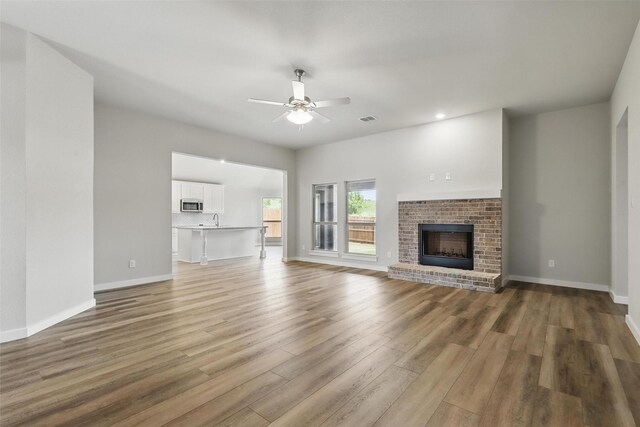 116 Mesa Dr, Glen Rose, TX 76043 - unfurnished living room featuring ceiling fan, light wood-type flooring, baseboards, a fireplace, and recessed lighting