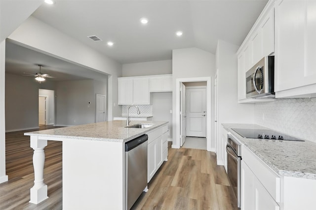 116 Mesa Dr, Glen Rose, TX 76043 - kitchen featuring a sink, stainless steel appliances, light wood finished floors, tasteful backsplash, and white cabinetry