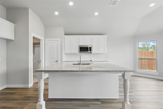116 Mesa Dr, Glen Rose, TX 76043 - kitchen with a sink, stainless steel microwave, light stone countertops, baseboards, and white cabinets
