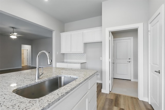 116 Mesa Dr, Glen Rose, TX 76043 - kitchen featuring a sink, wood finished floors, white cabinets, a ceiling fan, and light stone counters