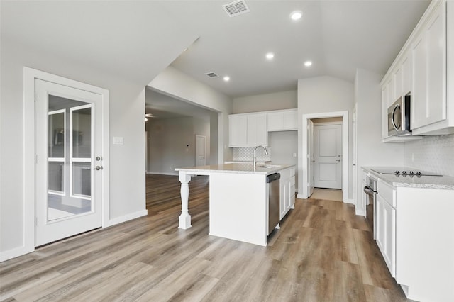 116 Mesa Dr, Glen Rose, TX 76043 - kitchen featuring stainless steel appliances, a sink, decorative backsplash, light wood-style flooring, and white cabinets