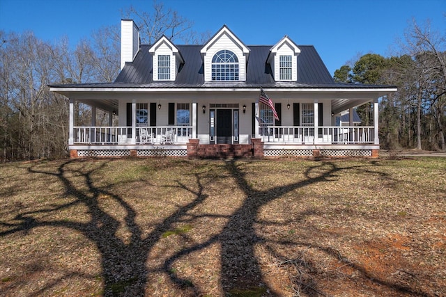 farmhouse inspired home featuring a chimney, a front yard, and a porch