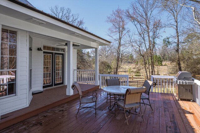 deck with area for grilling, outdoor dining area, and ceiling fan