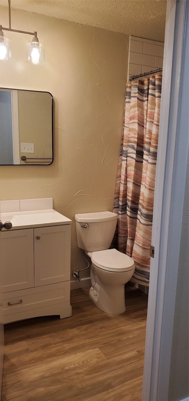 425 Oxford Dr, Sherman, TX 75092 - bathroom featuring a textured ceiling, wood finished floors, toilet, vanity, and a shower with curtain