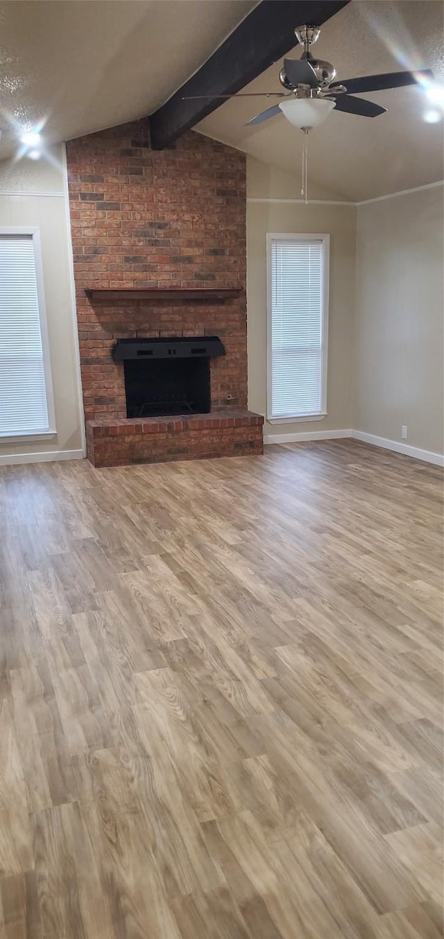425 Oxford Dr, Sherman, TX 75092 - unfurnished living room featuring a ceiling fan, wood finished floors, a brick fireplace, baseboards, and beamed ceiling