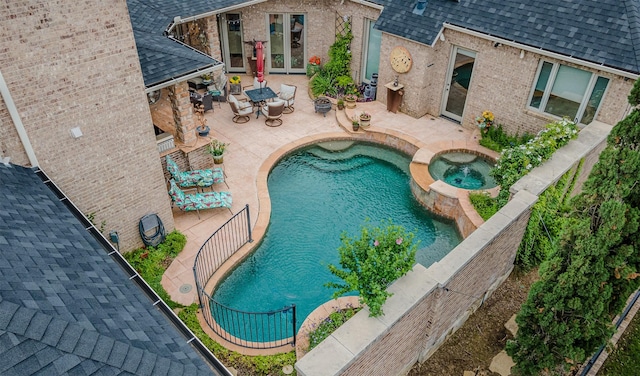 view of pool with french doors, a pool with connected hot tub, and a patio area