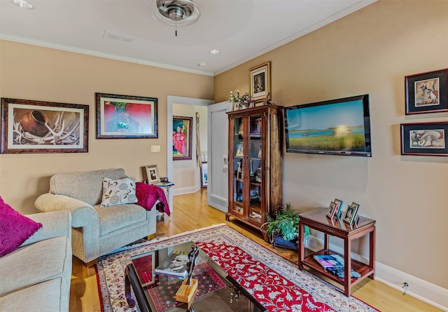 living room with baseboards, visible vents, wood finished floors, and ornamental molding