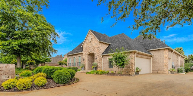 view of front of property with a shingled roof, a garage, brick siding, and concrete driveway