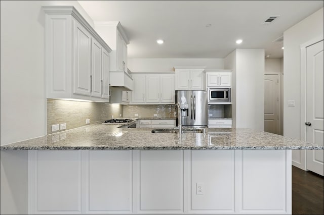 kitchen with visible vents, a sink, decorative backsplash, and stainless steel appliances