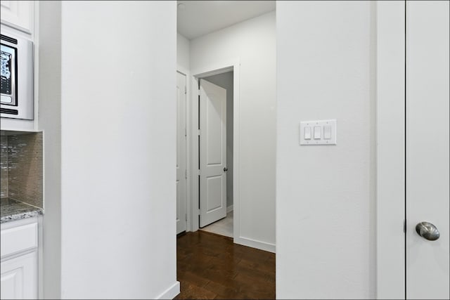 hall with baseboards and dark wood finished floors
