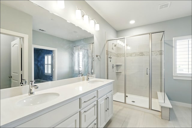 full bath featuring a sink, a stall shower, and visible vents
