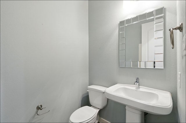 half bathroom featuring toilet and a sink