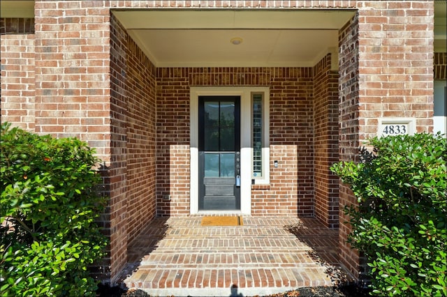 doorway to property with brick siding
