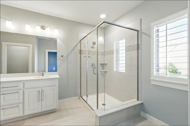 bathroom featuring vanity, baseboards, and a shower stall