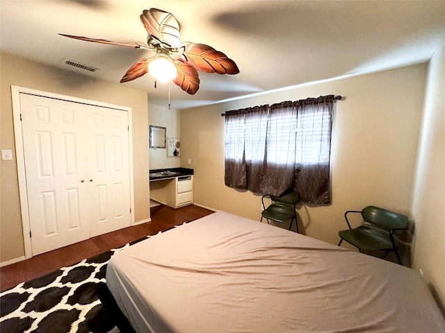 311 S Fir Ave, Munday, TX 76371 - bedroom featuring dark wood-style floors, a closet, ceiling fan, and visible vents