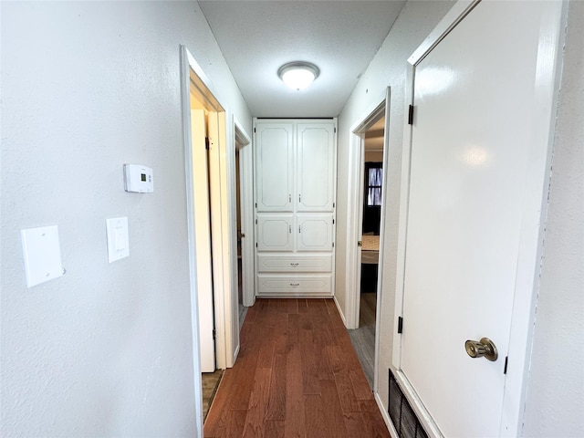311 S Fir Ave, Munday, TX 76371 - corridor with dark wood finished floors and visible vents