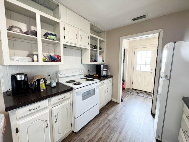 311 S Fir Ave, Munday, TX 76371 - kitchen with wood finished floors, dark countertops, open shelves, and white appliances