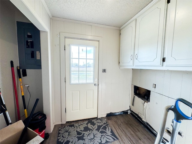 311 S Fir Ave, Munday, TX 76371 - doorway to outside featuring a textured ceiling, dark wood-style floors, electric panel, and ornamental molding