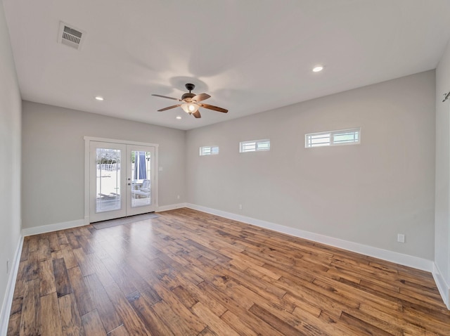 empty room featuring baseboards, ceiling fan, wood finished floors, recessed lighting, and french doors
