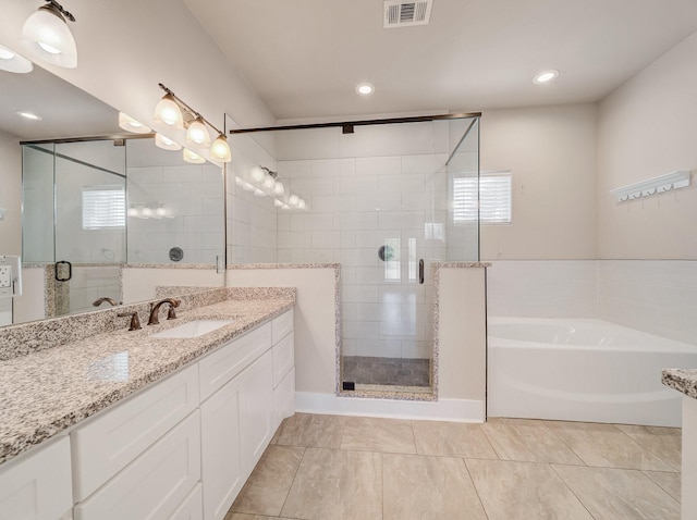 bathroom with visible vents, a garden tub, vanity, and a stall shower