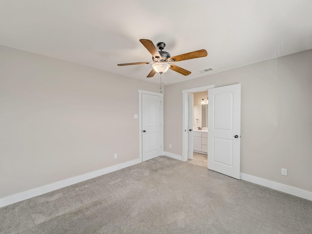 unfurnished bedroom featuring baseboards, connected bathroom, visible vents, and light colored carpet
