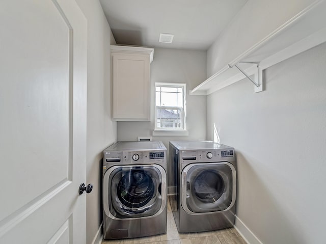 laundry area featuring cabinet space, washing machine and dryer, baseboards, and visible vents