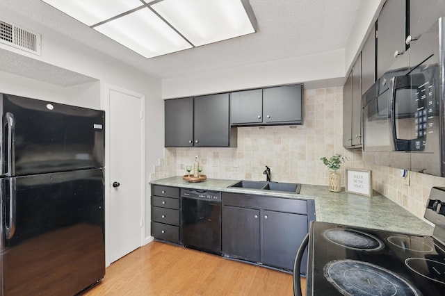 2700 Stonehaven Ct, Irving, TX 75038 - kitchen with black appliances, decorative backsplash, a sink, and light wood-style floors