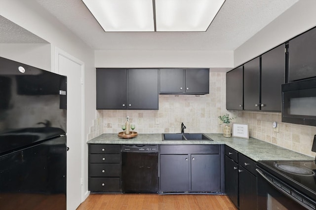2700 Stonehaven Ct, Irving, TX 75038 - kitchen with light wood finished floors, a sink, decorative backsplash, black appliances, and a textured ceiling
