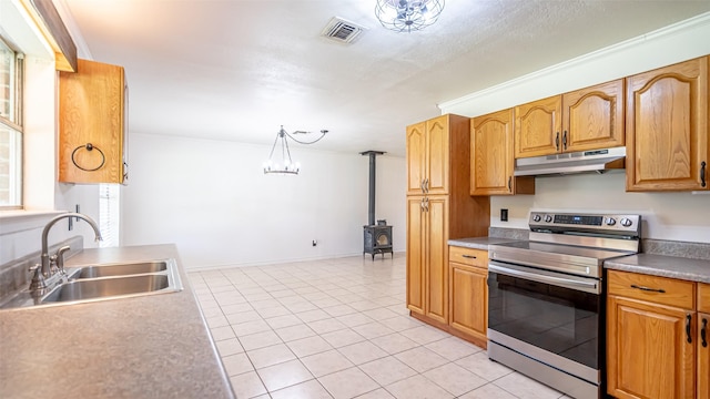 kitchen with under cabinet range hood, a sink, visible vents, a wood stove, and stainless steel range with electric stovetop