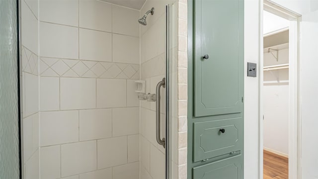 full bath with wood finished floors and a shower stall