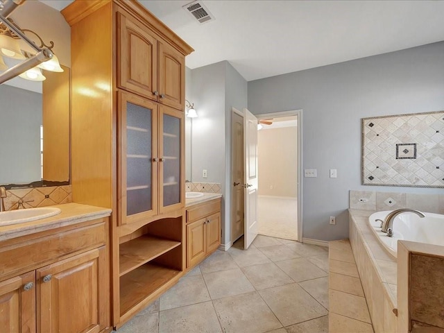 1904 Loblolly Ln, Lufkin, TX 75904 - full bathroom with two vanities, tile patterned flooring, tasteful backsplash, a garden tub, and baseboards