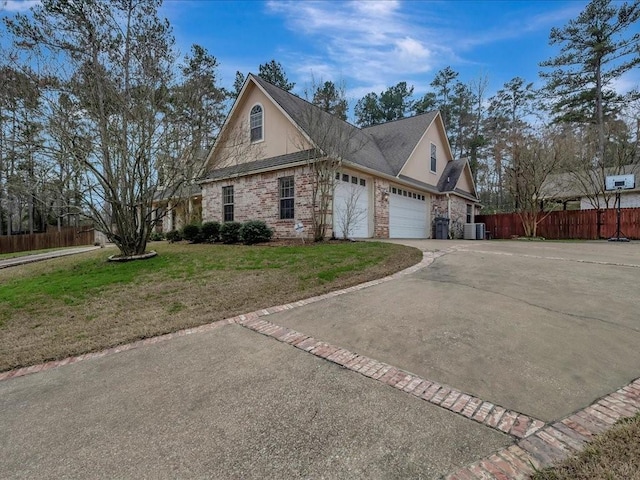 1904 Loblolly Ln, Lufkin, TX 75904 - view of side of home featuring a garage, driveway, brick siding, and central AC unit