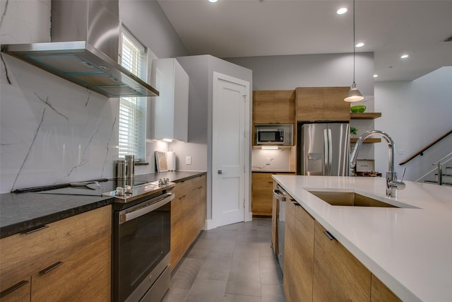 2239 Lovedale Ave Unit 105, Dallas, TX 75235 - kitchen featuring a sink, wall chimney range hood, brown cabinets, modern cabinets, and appliances with stainless steel finishes
